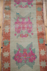 Distressed Oushak runner section: pink floral bouquets, seafoam green, and worn rust starburst border.