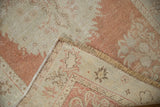 Distressed pile texture, intact side selvage, and fringe on vintage Oushak rug.