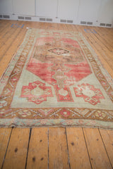 Distressed Oushak runner fringe and geometric border in faded raspberry, bronze, aqua.
