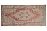 Vintage distressed Oushak rug runner with a faded red stepped medallion and beige field.