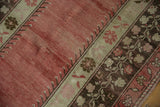 Vintage distressed Oushak rug's faded red field and charcoal meandering vine border.
