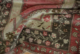Distressed Oushak rug pile shows even wear, faded reds, ivory, and charcoal brown vine patterns.