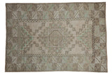 Distressed vintage Melas rug with geometric medallion and lattice pattern in ivory, seafoam green.