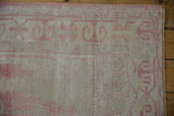 Pale raspberry ram's horn border and short pile on this vintage distressed Oushak runner.