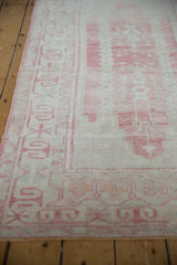 Distressed Oushak runner border with pale raspberry ram's horn motifs on an ivory field.
