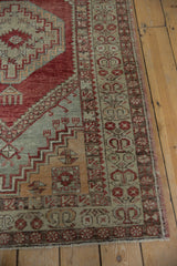 Distressed cherry red and silver geometric border with intact selvage on a vintage Oushak rug.