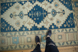 Distressed Vintage Oushak carpet's banded Samovar border with blue, ivory, and sand tones.