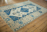 Vintage Oushak rug corner, featuring indigo and pale blue serrated leaf border.