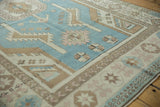 Vintage Distressed Oushak carpet detail, softened denim blue field, serrated leaves, and ivory border.