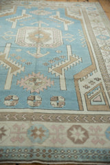 Distressed denim blue field, ivory serrated leaves, and pinwheel motifs.