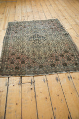 Antique Farahan Sarouk rug corner: blossomed henna plant motif, dusty rose, ivory, tattered end.