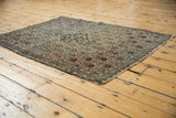 Finely woven blossomed henna motif and tattered edge of this antique Farahan Sarouk rug.