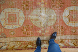 Vintage Khotan runner: pale terracotta medallion, floral field, geometric border, and visible texture.