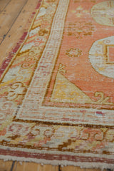 Vintage Khotan rug detail, terracotta, ivory, gold geometric border, faded floral field.