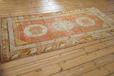 Corner detail of vintage Khotan runner, showing cloud band and infinity borders in orange, ivory.