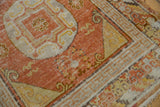 Intricate pale orange terracotta and ivory cloud band border of a vintage Khotan runner.