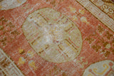 Uzbeki Khotan rug's pale terracotta field, ivory medallion, and wear to knot heads.