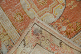 Vintage Khotan rug runner corner, showing terracotta and ivory pile with visible foundation wear.