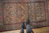 A perspective view over the golden field and rare copper-green border of an antique Persian rug.