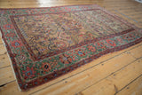 Angled view of a collector's Persian Farahan Sarouk showing its golden field and rare green border.