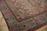 The rare copper green border contrasts with the gold field on this antique Farahan Sarouk rug.