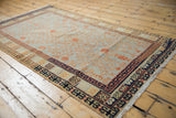 Distressed Khotan rug corner, showing geometric borders and terracotta vinery.