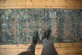 Distressed vintage Mahal runner showing muted blue and red floral patterns on worn pile.