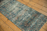 Distressed vintage Mahal runner detail, with worn dusty blue, red motifs and exposed foundation.