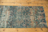 Secured end of the distressed Mahal runner, revealing worn blue and red floral patterns.