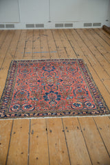 Vintage Lilihan rug corner: brick red field, navy blue border, worn fringe.