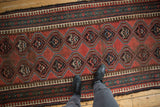 Antique Caucasian runner's repeating madder red medallions and multi-colored pawn motif borders.