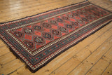 Antique Caucasian runner with madder red repeating medallions and mallard green pawn motif borders.