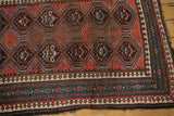 Caucasian runner corner: madder red geometric borders, reciprocating pawn motif, ivory, and wear.