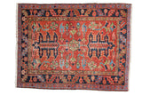 Antique Persian Heriz rug, brick red field with oversized palmettes and geometric motifs, navy border.