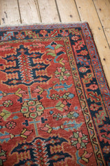 Antique Heriz rug's brick red field with navy, sky blue, green palmette motifs.