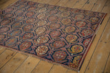Antique Afshar fragment rug with repeating indigo, brick, and gold boteh lattice pattern.