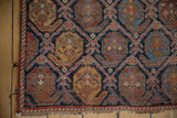Antique Afshar rug: detailed boteh motif, foundation visible, in indigo, brick red, and saffron.
