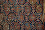 Antique Afshar fragment's indigo and brick red boteh lattice pattern, showing wear and foundation.