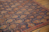 Angled detail of Persian Afshar rug: indigo lattice with brick red, gold boteh motifs.