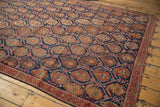 Close-up of antique Persian Afshar rug's indigo lattice, repeating brick red boteh, and visible knot head wear.