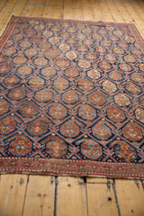 Antique Persian Afshar rug's lattice and repeating boteh motifs in aged indigo and brick red.