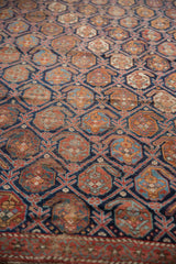 Close-up of antique Afshar fragment showing indigo blue lattice with aged brick red boteh.