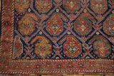 Afshar rug corner detail with brick red border, indigo boteh lattice, saffron accents, and storied wear.