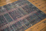 Vintage Turkmen rug detail with germinating plant motif, aubergine, charcoal, ivory, and aged texture.