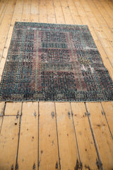 Distressed Turkmen rug, with time-softened aubergine tones and worn edge.