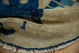 Deep blue and beige short pile texture with tattered fringe on an antique round Peking rug.