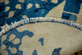 Fringed edge and woven reverse of the cobalt blue antique Peking pictorial rug.