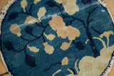 Antique Chinese Peking rug detail: blue and beige leaves with exposed foundation and tattered edge.