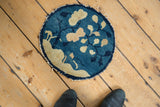 Tattered edge of an antique Peking rug, showing cobalt blue and ivory pictorial leaves.