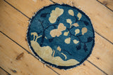 Tattered edge detail of the antique Peking rug, with cobalt blue and beige leaves.